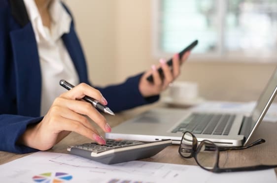 Finance professional reviewing invoices on a laptop